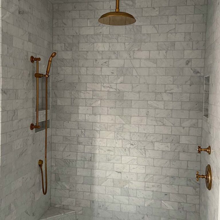 walk-in shower remodel with grey tile and copper finishes
